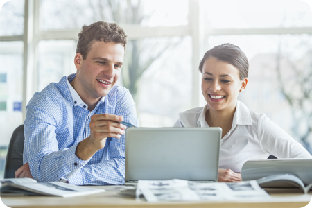 Male assessor with young female learner on a laptop